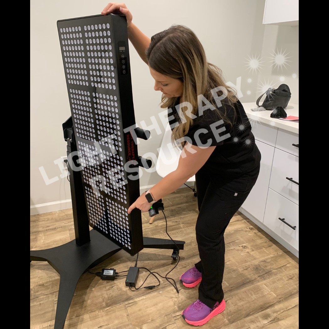 Dr. Sara Whatley positioning the Light Therapy Resource Red and Infrared Light Panel in her office.