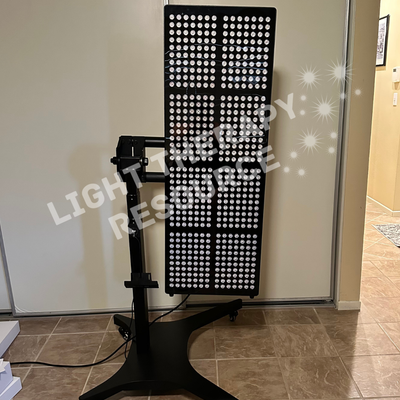 Red and Infrared light therapy panel on a stand in a room with a white wall and tiled floor.