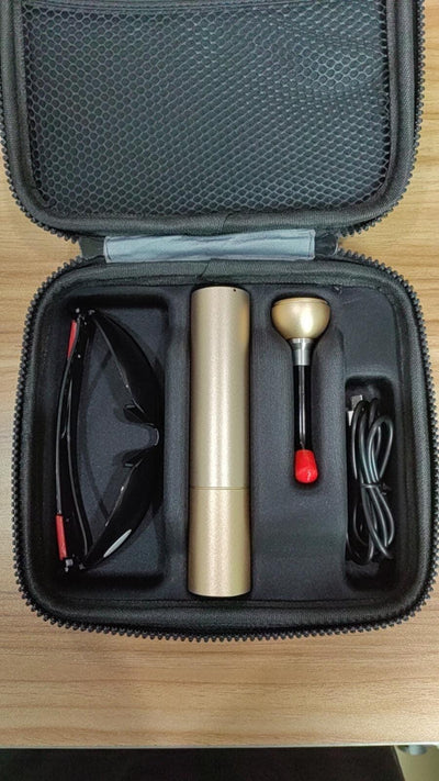 Handheld red light therapy device in a travel case. It comes with safety glasses, a charger cord and a fiber head attachment.