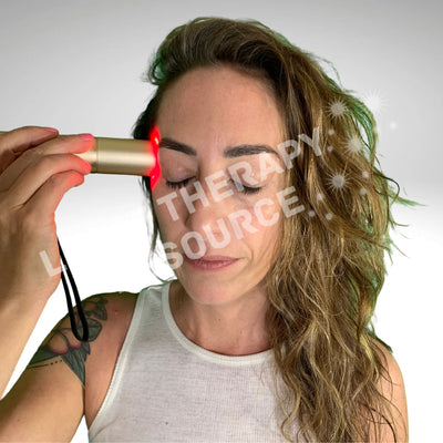 A woman receiving red light therapy on the side of her face near her temple with a red light therapy torch with text overlay 'Therapy Resource.'
